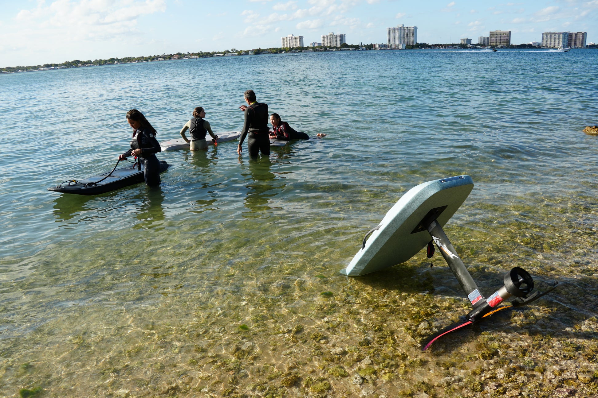 Two riders learning electric surfboards on the shallow flats of Biscayne Bay