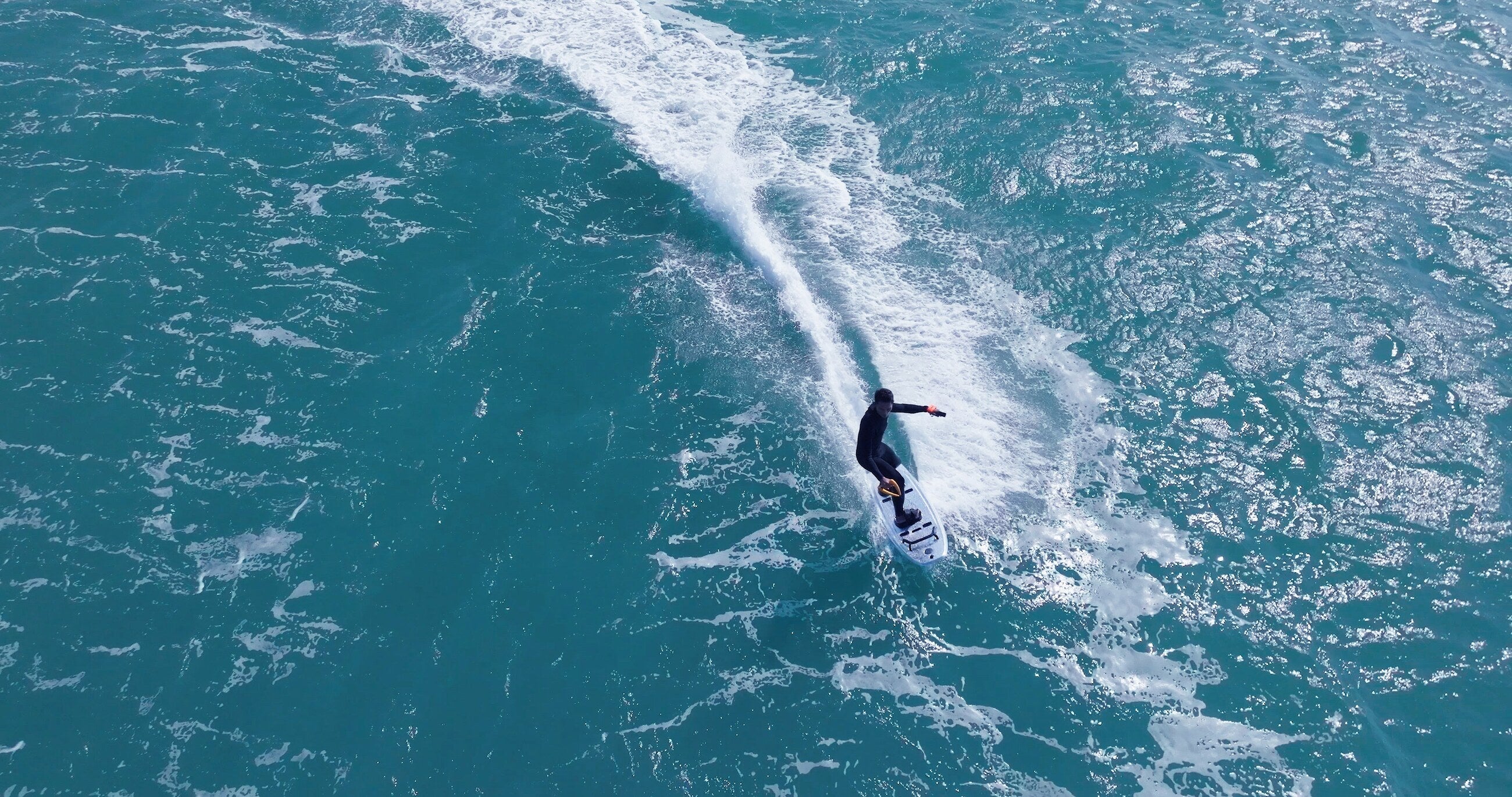 Moovi electric surfboard rider on a wave